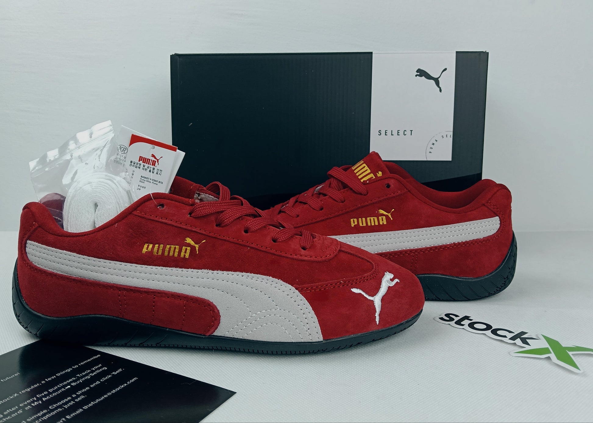 Red and white Puma sneakers with packaging on a light gray background